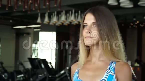 漂亮的女孩在健身房的跑步机上跑步全脸画像视频的预览图