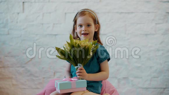 可爱的小女孩展示鲜花和礼物视频的预览图