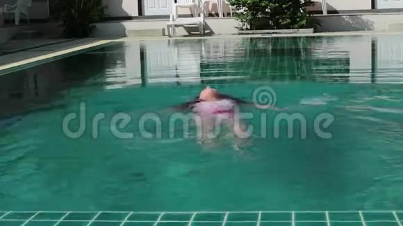 小女孩跳进游泳池里暑假的欢乐时光视频的预览图