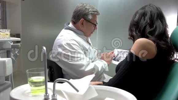牙医拿着X光和病人视频的预览图