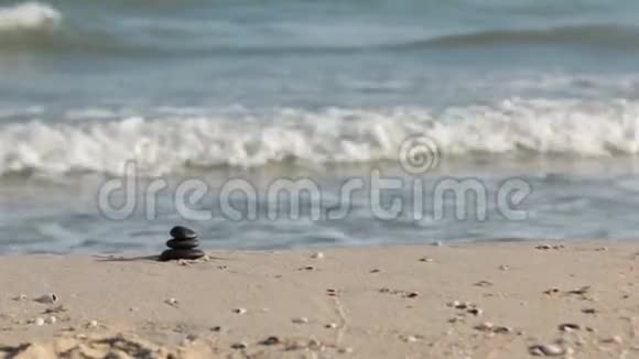 在沙子上放大石头金字塔以海波为背景象征禅宗视频的预览图