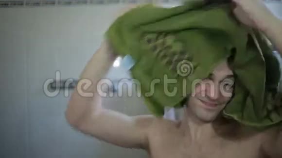 男人在镜子附近用毛巾擦拭头发身体护理头发护理视频的预览图
