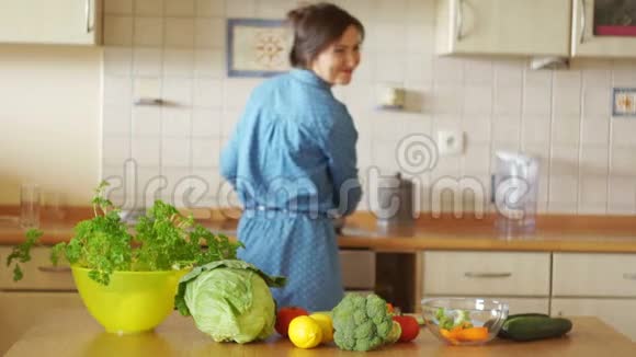 一个年轻的女人正在准备一个汤在炉子和桌子之间跳舞心情很好家庭厨房素食主义健康视频的预览图