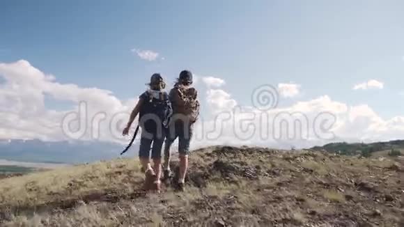 儿童旅行者两个带背包的小女孩徒步旅行牵着手儿童旅游视频的预览图