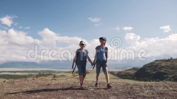 与儿童一起旅游儿童旅行者两个带背包的小女孩徒步旅行牵着手视频的预览图