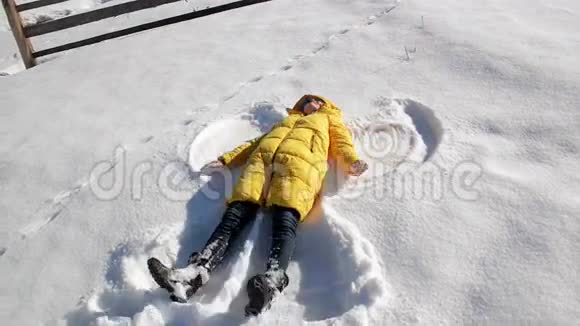 在外面的一天里女孩躺在地上让雪天使开心欢乐的女人视频的预览图