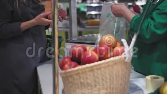一位年轻的时髦女性在商店里称水果视频的预览图