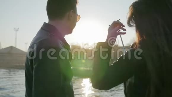 风发背景灯情侣在智能手机上拍照幸福年轻夫妇的自拍照视频的预览图