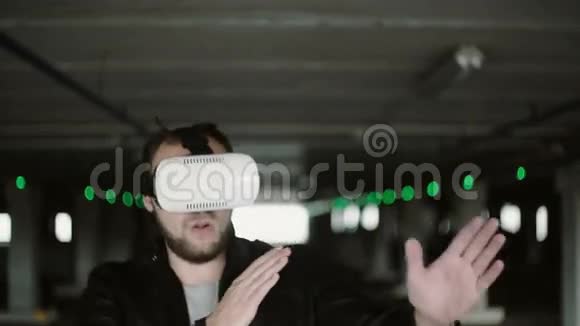 年轻人站在停车场用虚拟现实眼镜玩得开心的VR耳机4K视频的预览图