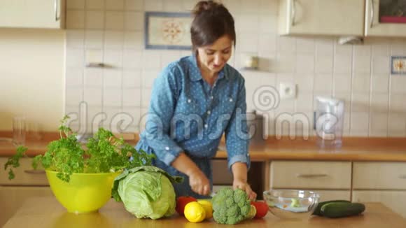 厨房里的家庭主妇心情很好她切蔬菜用胡萝卜唱歌好像她是一个麦克风视频的预览图