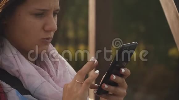 一个年轻的女人在早晨的阳光下在智能手机上拍照视频的预览图