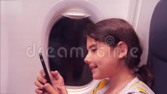 航空飞机概念小女孩正坐飞机在窗户旁边聊天寻找生活方式视频的预览图