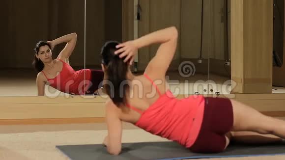 健身女子腿在健身房锻炼穿短裤的漂亮健身女人做腹部按摩视频的预览图