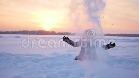 孩子在日落时分在冬天的公园里尽情地撒雪视频的预览图