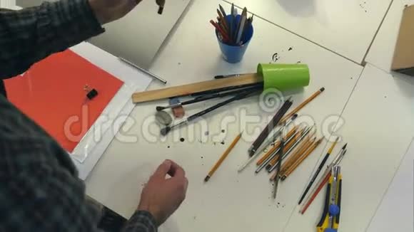 画家将画笔和削尖的铅笔放在不同的罐子里视频的预览图