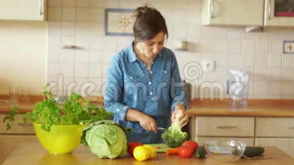 厨房里的深色头发正在碎花椰菜那个女孩跳舞唱歌家庭厨房视频的预览图