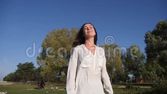 快乐兴奋混合种族妇女在自然中微笑和放松的肖像穿着白色亚麻衬衫视频的预览图