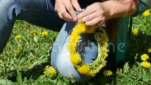 春天的晴天女孩手织一个黄色的花圈手工装饰在头上视频的预览图