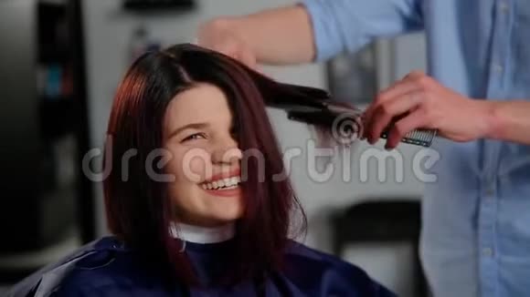 理发师在美发沙龙为女性理发的反思时尚与美的概念视频的预览图
