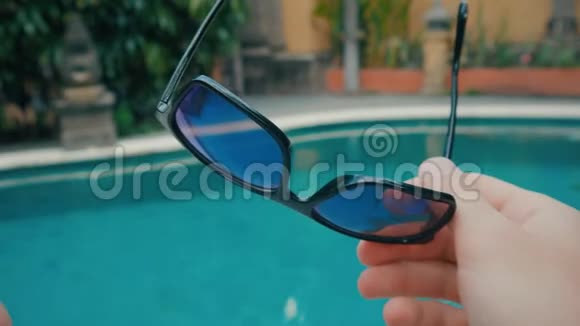 第一人称景观夏天人们在泳池背景的度假胜地戴上太阳镜视频的预览图