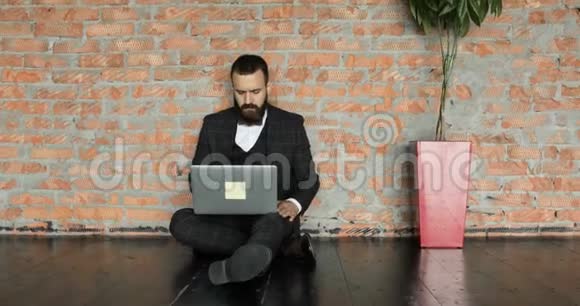 一个穿西装的男商人正在一个阁楼风格的现代办公室工作一个专心致志的人在项目上工作视频的预览图
