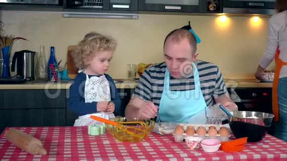 幸福家庭在厨房一起做蛋糕的画像视频的预览图