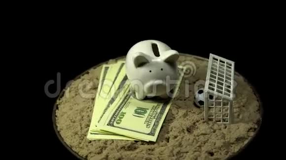 一个白色的储蓄罐和美元钞票在黑色的背景上旋转视频的预览图