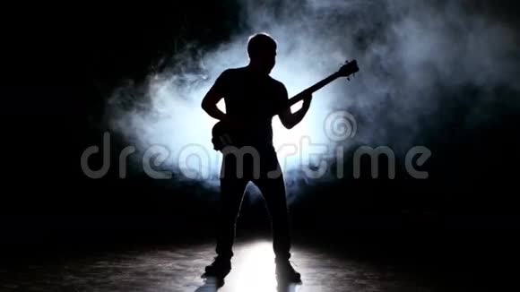 野心勃勃的吉他手在烟雾中演奏乐器视频的预览图