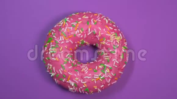 美味的甜面圈在盘子上旋转上景紫色背景视频的预览图