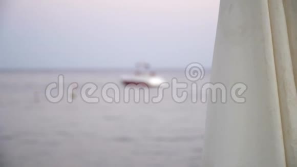 海中船只背景上折叠的海滩伞休闲的坏天气视频的预览图
