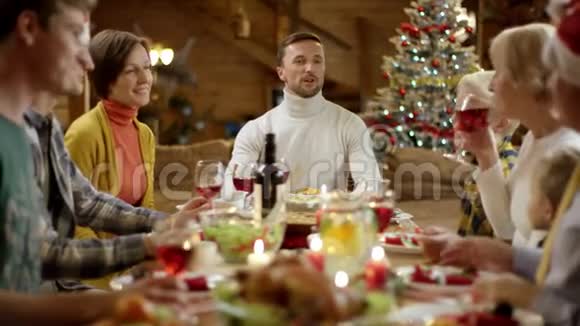 女人在朋友节日晚餐时给男人圣诞礼物视频的预览图