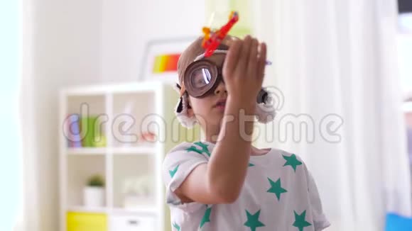 戴着飞行员帽子的男孩在家玩飞机玩具视频的预览图