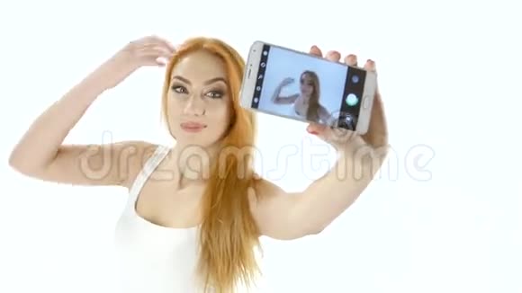 可爱的红头发女孩在你的智能手机上自拍白色背景视频的预览图