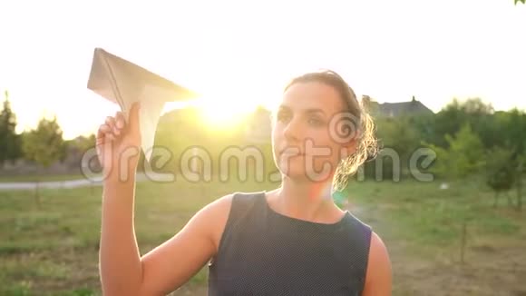 女人在日落的背景下发射纸飞机梦想旅行或空姐的职业视频的预览图
