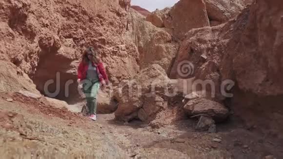 女孩沿着一个不寻常的地形旅行红色的地球和山脉就像火星一样视频的预览图