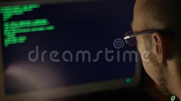 黑客试图闯入坐在显示器前面的计算机代码视频的预览图