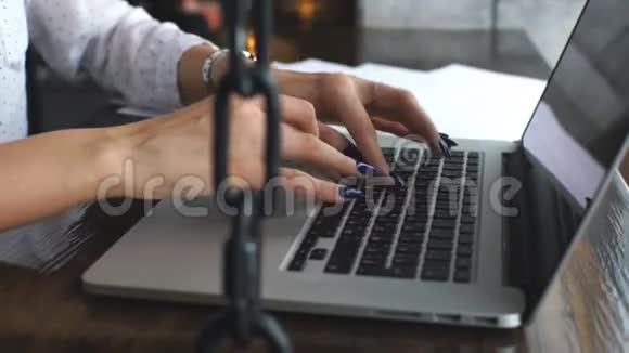 一个穿白色衬衫的年轻女商人在笔记本电脑上打印视频的预览图