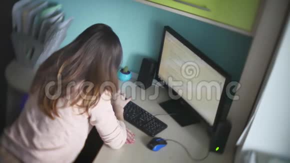 穿着牛仔裤和毛衣的女孩在网上坐在办公桌前的现代办公室慢动作视频工作在视频的预览图