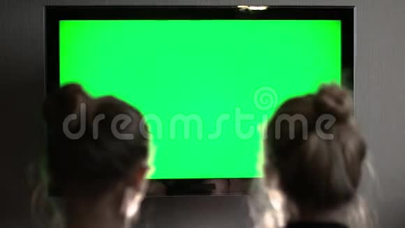 两个年轻的金发金发金发女郎看着绿色的电视屏幕突然转过头来视频的预览图