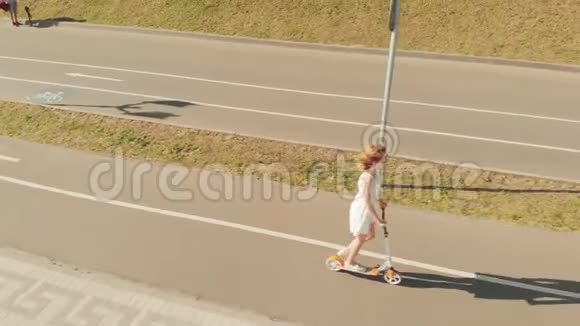 夏天在户外骑滑板车的女人空中射击视频的预览图