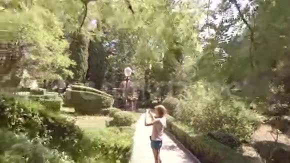 两个女孩走过夏天的花园绕着镜头拍摄视频的预览图