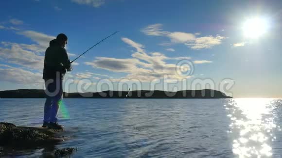 非常接近工作渔夫的后视镜男人检查推饵把它扔到海里手拿鱼竿的渔夫视频的预览图