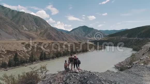 空中飞行游客的家人一个年轻的女人和男人带着孩子走在山上的一条小路上年轻的母亲视频的预览图
