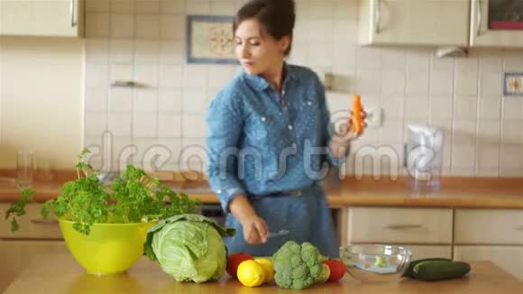 一个甜的黑发女人正在厨房里切蔬菜她嗅着欧芹的绿色愉快地吃了一块视频的预览图