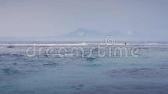 美丽的蓝色海浪和一座山的背景缓慢运动视频的预览图