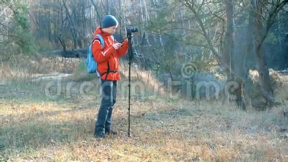 十几岁的男孩在秋林的单足动物和单足动物上拍摄视频的预览图
