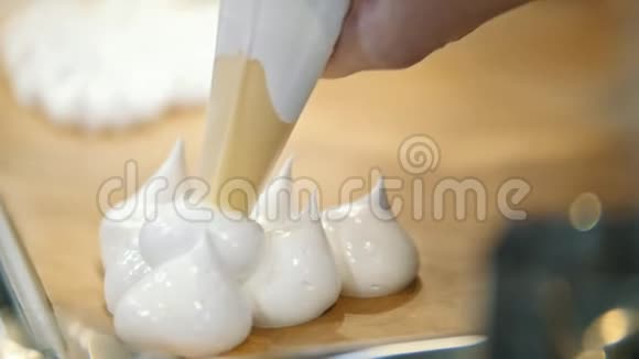厨师在厨房里做饭糕点管在烤盘上铺上奶油帕夫洛娃甜点视频的预览图