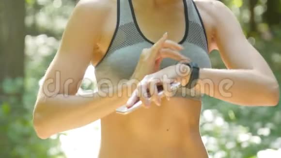 一个女人在锻炼时看健身追踪器视频的预览图