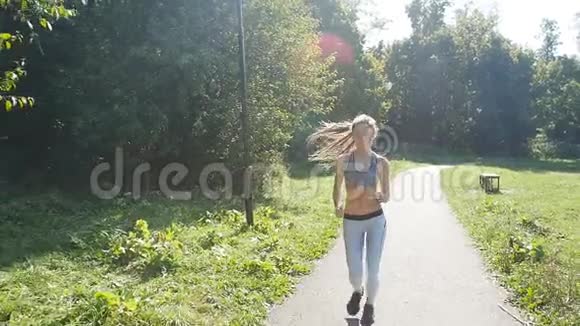 在公园慢跑的漂亮年轻运动女子视频的预览图