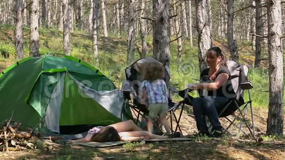 母子俩在树林里玩毯子小可爱的男孩和他的母亲一起在营地里度过大自然的时光视频的预览图